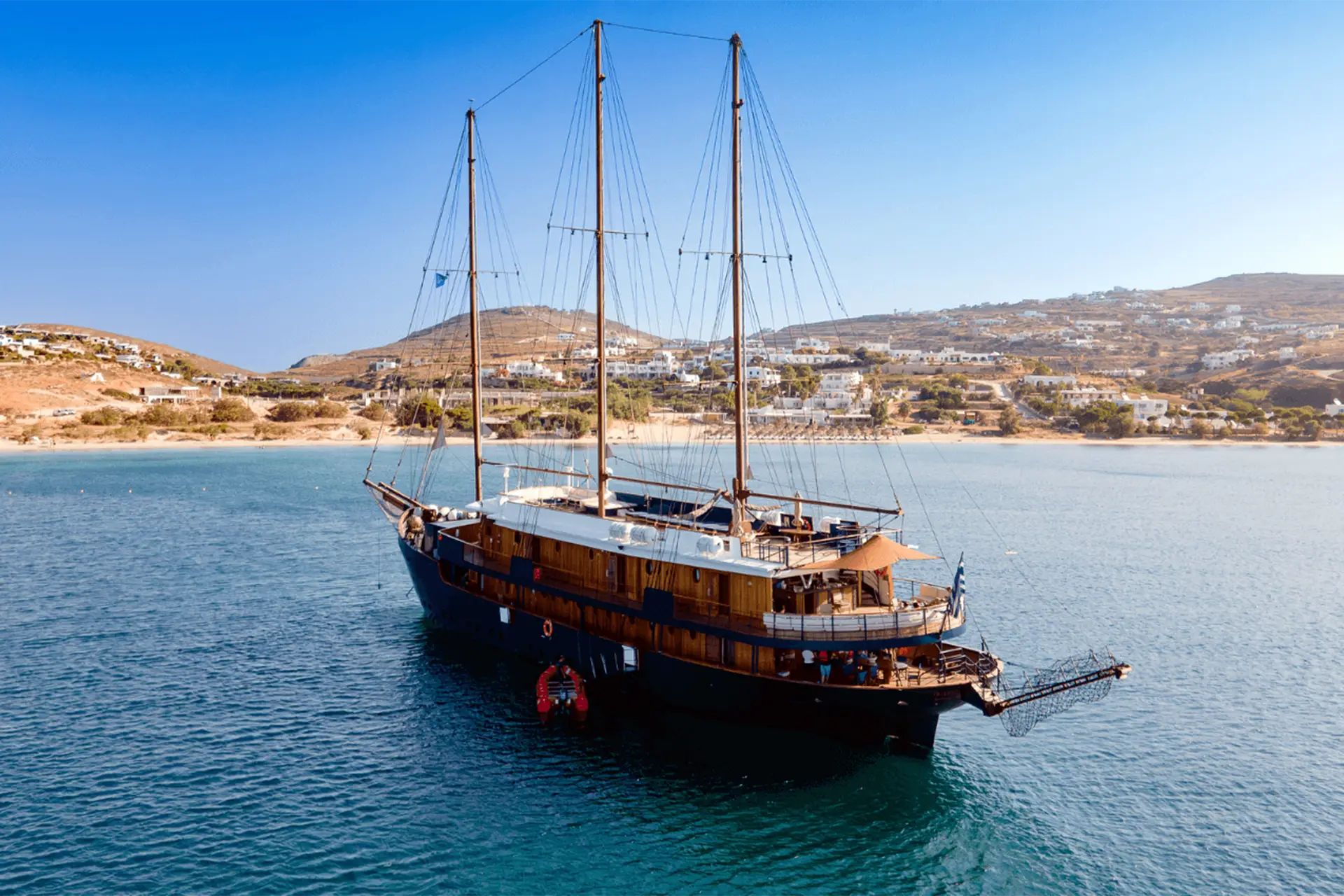 Race2Adventure Greece 2028 adventure exterior view of three mast ship off the shore of a greek isle on a sunny day
