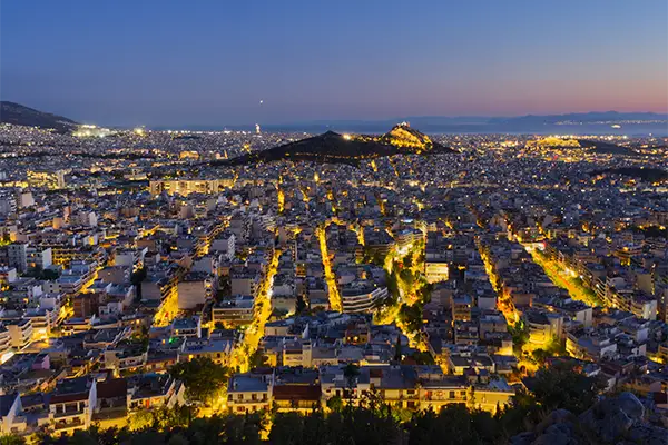 Race2Adventure Greece 2028 global vacation adventure illuminated Athens aerial at dusk. Run, seek, adventure!