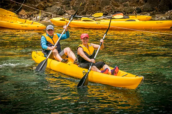 Race2Adventure Greece 2028 global vacation adventure smiling paddling a tandem kayak. Run, seek, adventure!