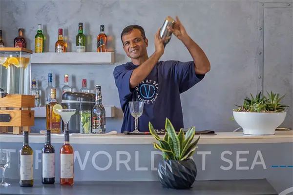 Race2Adventure Greece 2028 global vacation adventure an outdoor ship bar with smiling bartender. Run, seek, adventure!