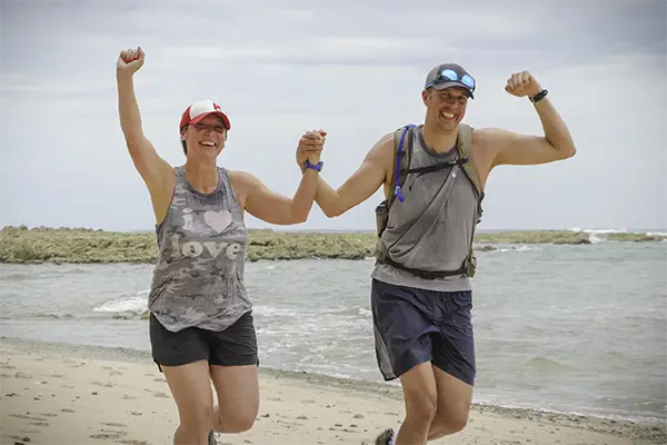 Race2Adventure Greece 2028 global vacation adventure smiling couple runs along a sunny beach. Run, seek, adventure!