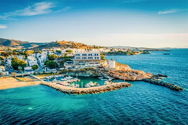 Race2Adventure Greece 2028 global vacation adventure aerial view of the greek island Paros surrounded by turquoise waters on a sunny day. Run, seek, adventure!