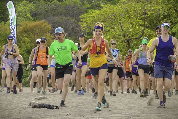 Race2Adventure Greece 2028 global vacation adventure big group runs on a sunny beach. Run, seek, adventure!