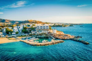 Race2Adventure Greece 2028 global vacation adventure aerial view of the greek island Paros surrounded by turquoise waters on a sunny day. Run, seek, adventure!
